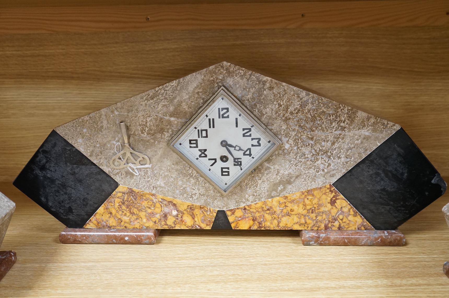 An Art Deco four colour marble clock garniture, with key